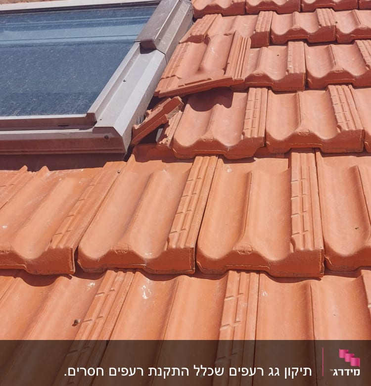 רעפים כתומים עם חלון גג על רקע שמיים כחולים